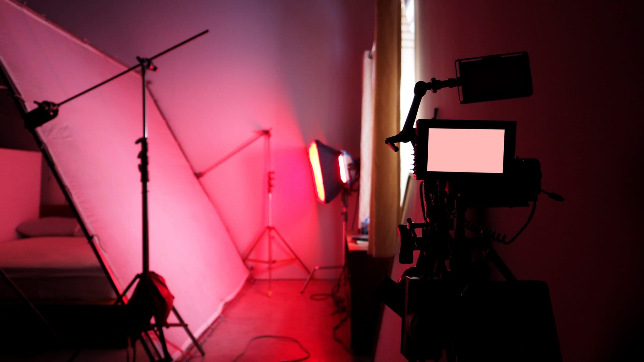 4K high definition video camera monitor on tripod or crane in studio and softbox paper and professional lighting equipment for shooting or filming or broadcasting content to advertising commercial
